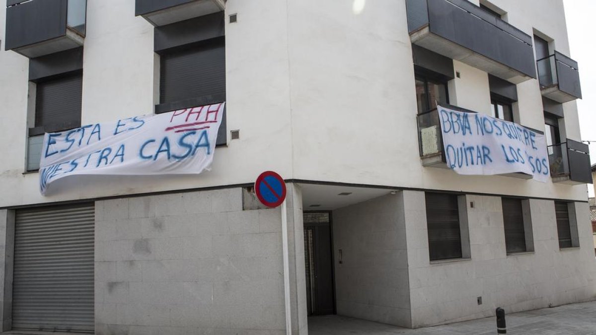 Pancartas de protesta penden de los balcones del piso en el cruce entre las calles Segle XX e Indústria.