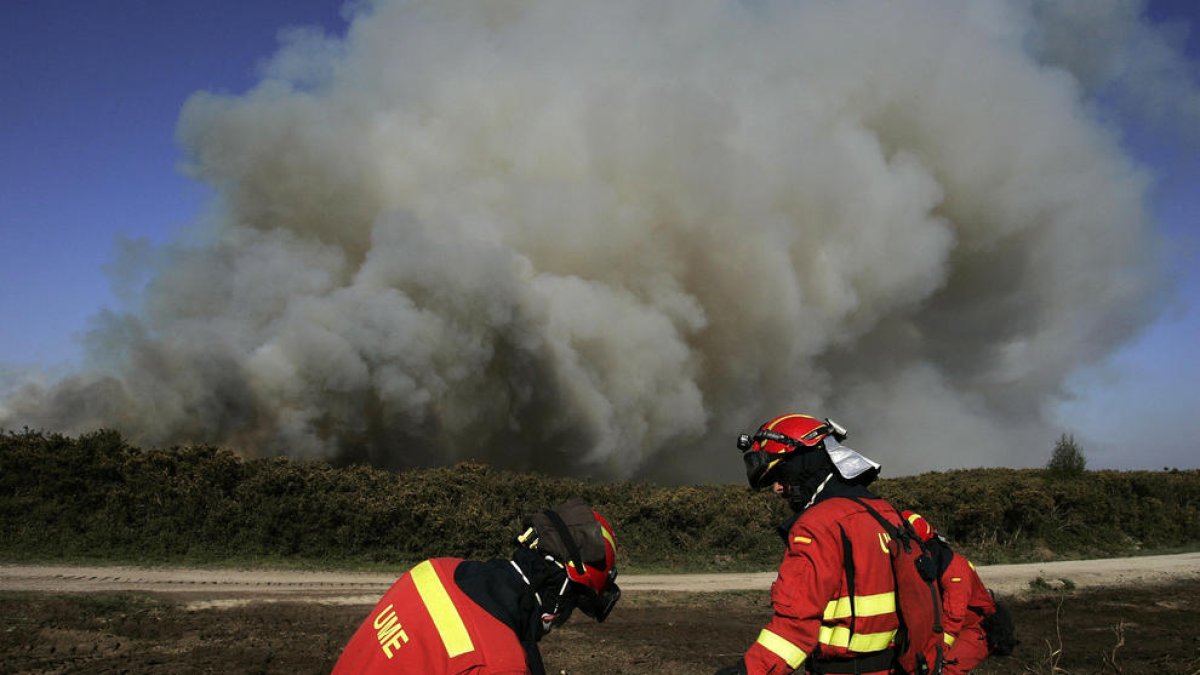 Efectivos de Bomberos durante las labores de extinción del incendio en el municipio coruñés de Narón.