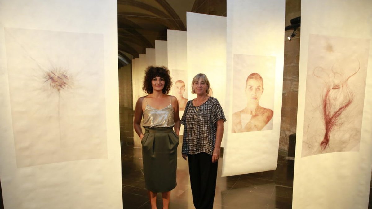 La fotógrafa Iolanda Sebé y la directora del IEI, Montse Macià, ayer junto a imágenes de la exposición.