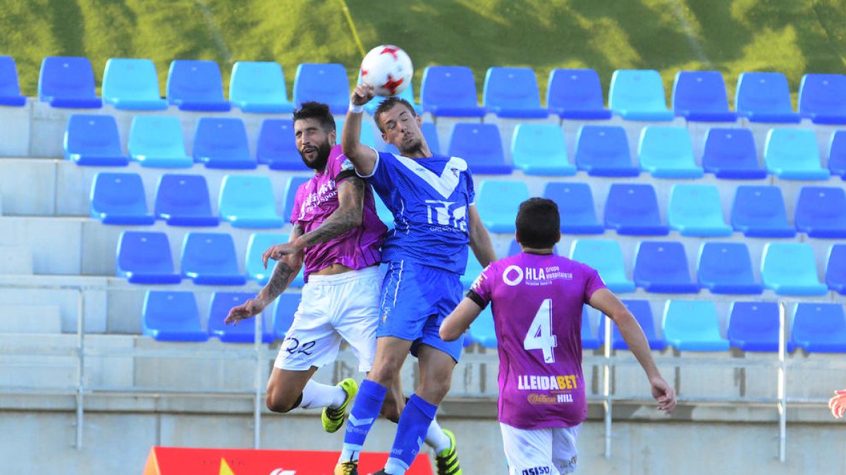 Trilles salta junto a un jugador del Badalona, ante la mirada de Lázaro.