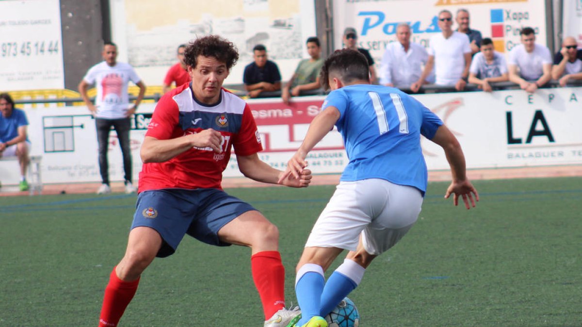 El jugador del Balaguer Carlos intenta impedir l’avanç d’un futbolista del Lleida Esportiu B.