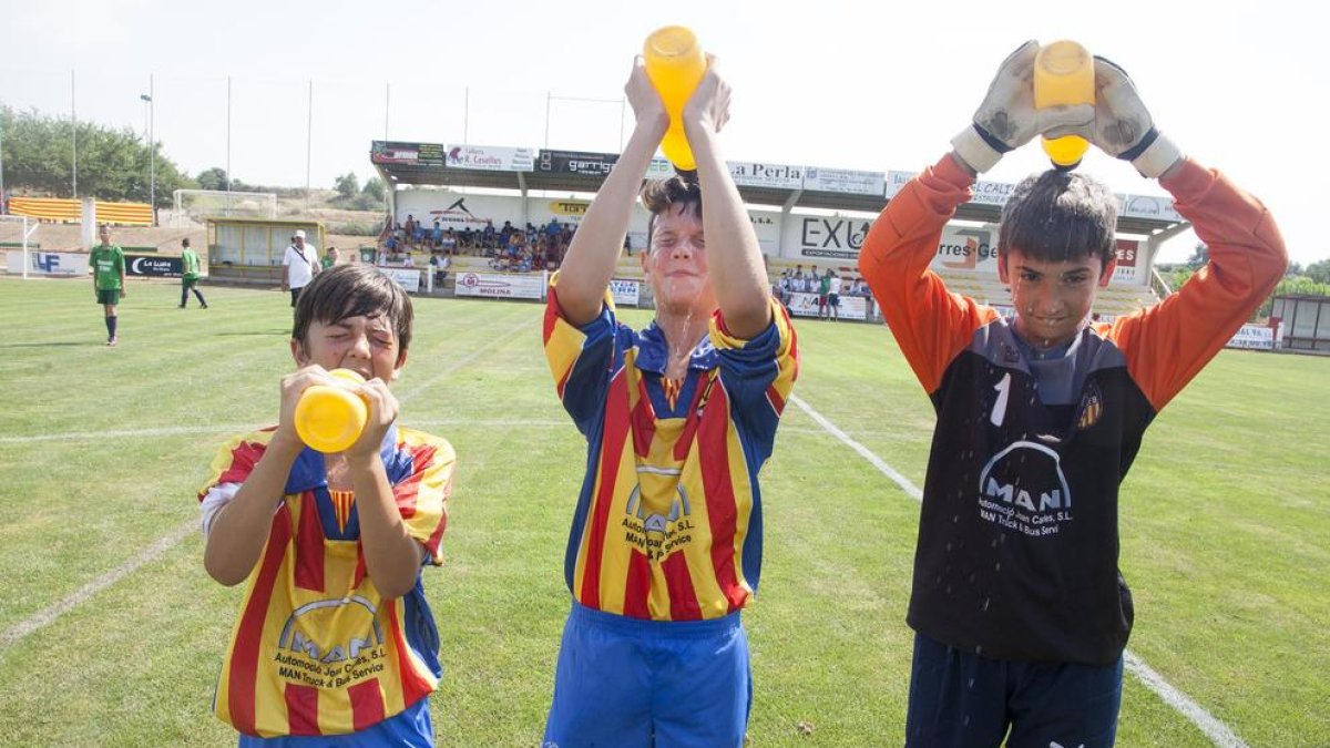 Jugadors del Bellpuig es refresquen tirant-se aigua pel cap abans de disputar un partit.