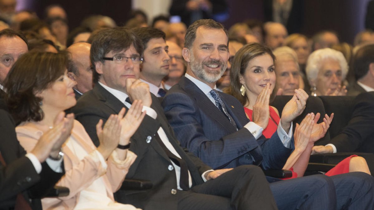 Soraya Sáez de Santamaría, Puigdemont y los reyes, ayer en un acto de entrega de becas de La Caixa.