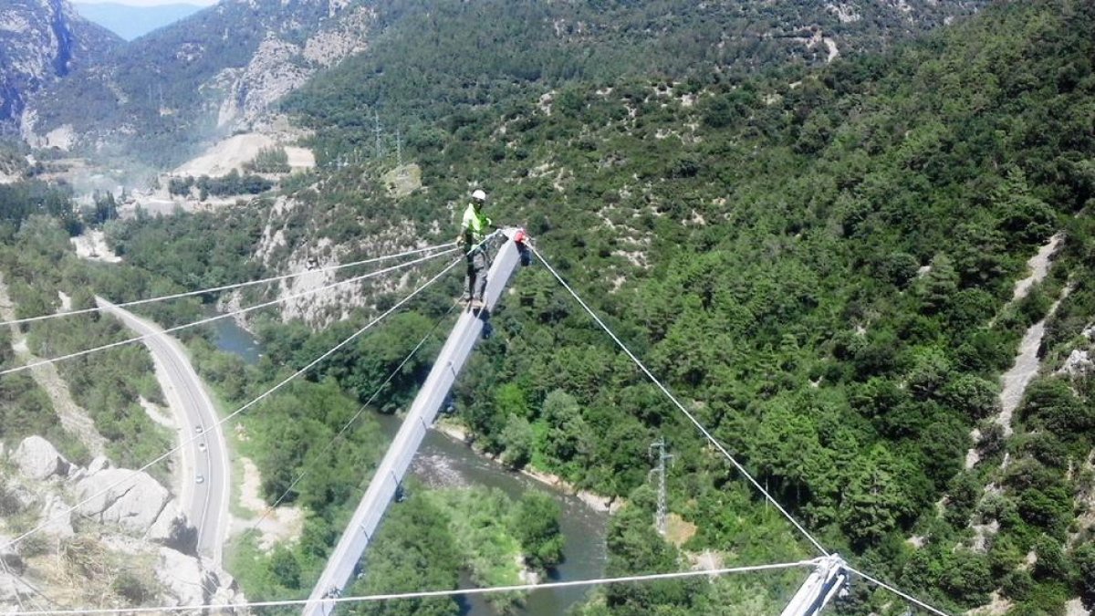 Un operari instal·lant pantalles per evitar la caiguda de roques a la C-14 el mes de juliol passat.