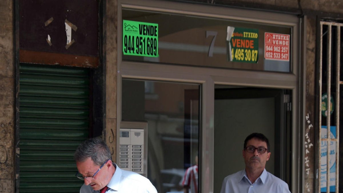 Empleats d’una funerària retiren el cadàver de la dona assassinada a Sestao.