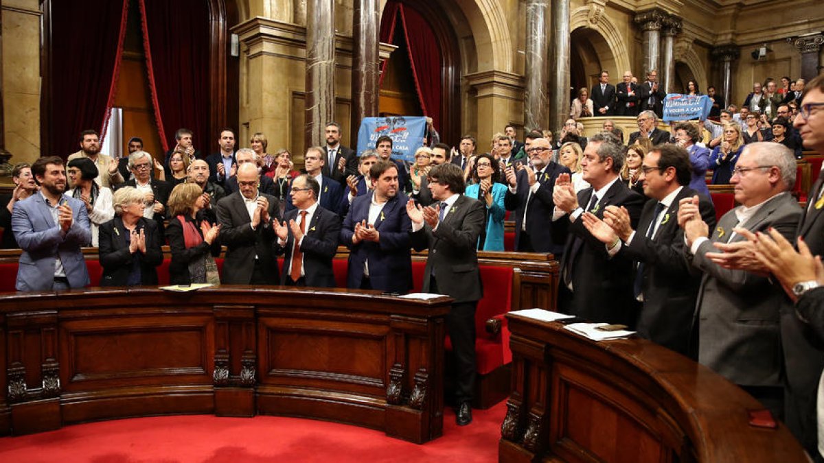 Vista dels membres del Govern i de Junts pel Sí aplaudint una vegada aprovada la resolució.