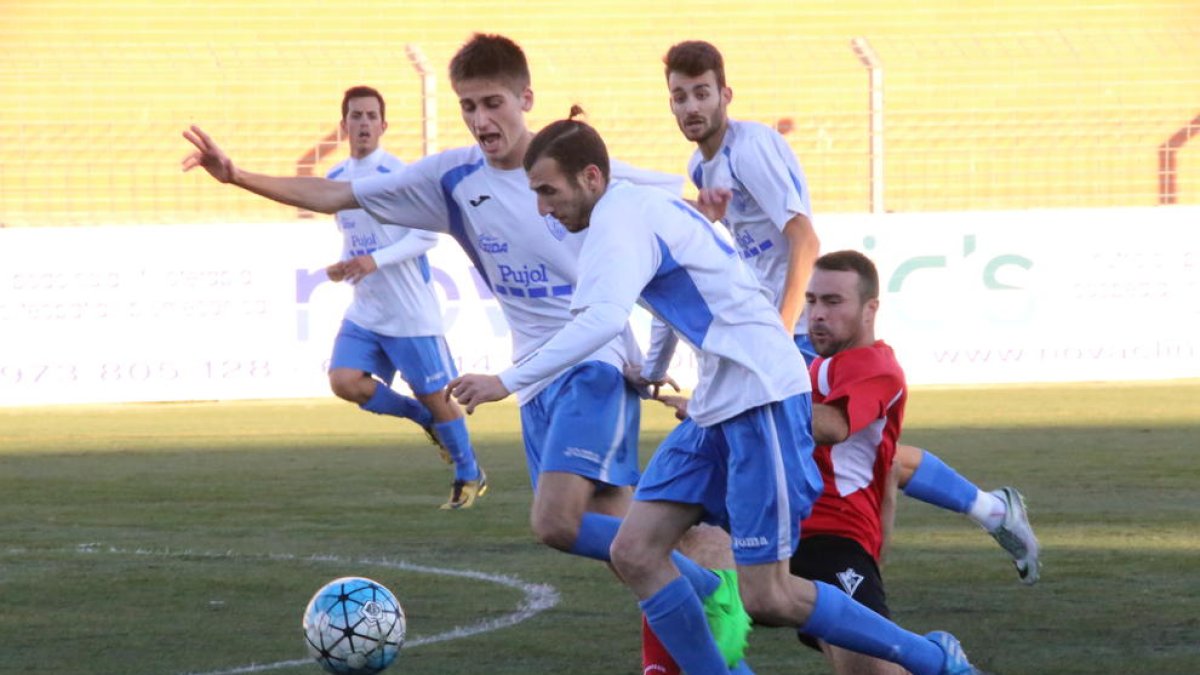 Diversos jugadors del Mollerussa protegeixen la pilota davant la pressió d’un jugador del Castellserà.