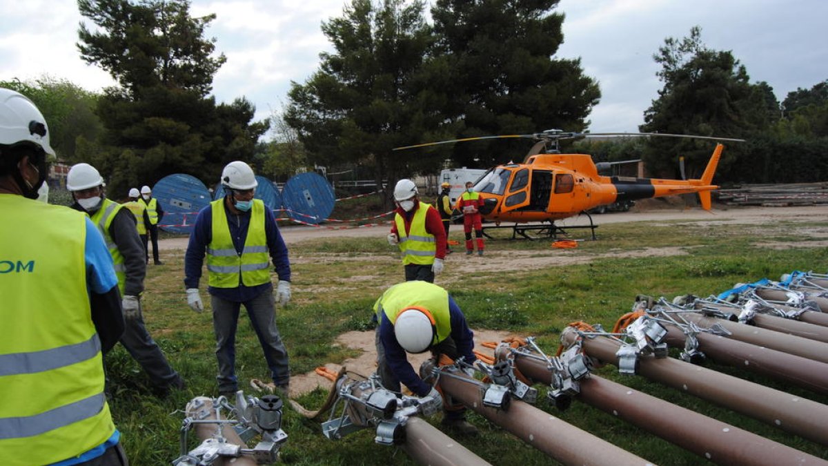Operaris treballant en una de les línies de les Garrigues.