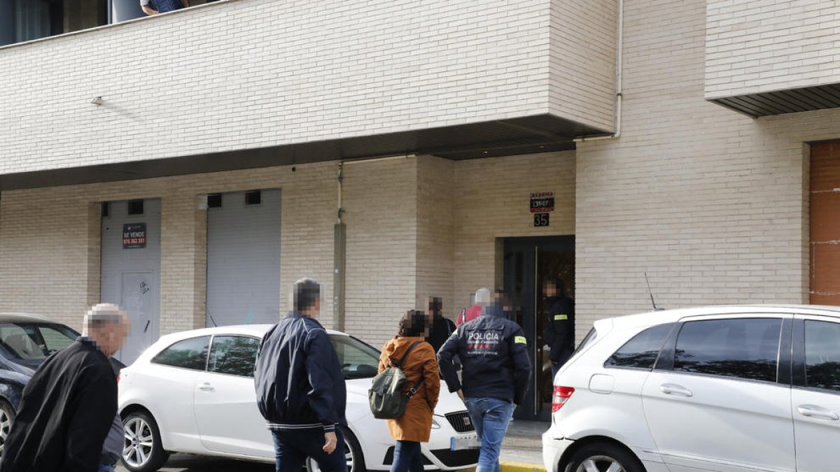Mossos i advocats entrant ahir al portal de l’edifici de Balàfia en què es va escorcollar un pis.