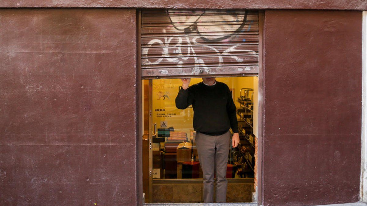 Un trabajador autónomo echa el cierre de su negocio tras finalizar su jornada laboral.