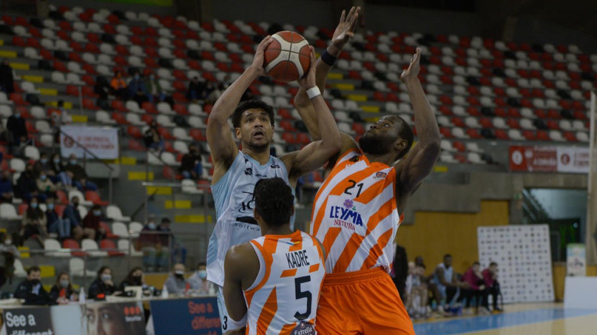 Hughes, que fue el segundo máximo anotador del equipo, tira a canasta.