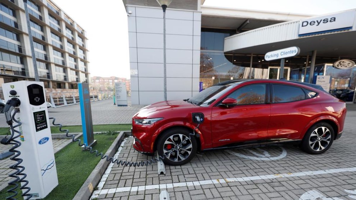 Imagen de un coche eléctrico en una estación de recarga a las puertas de un concesionario.