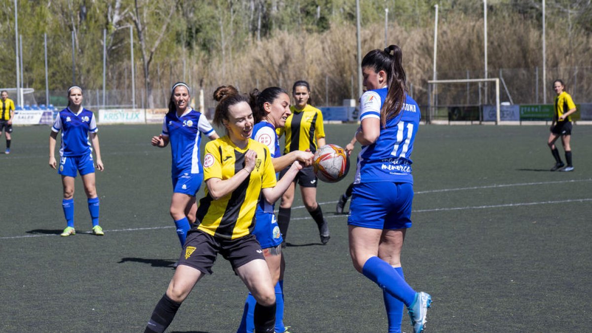 Una jugadora del Pardinyes disputa la pilota amb dos rivals.