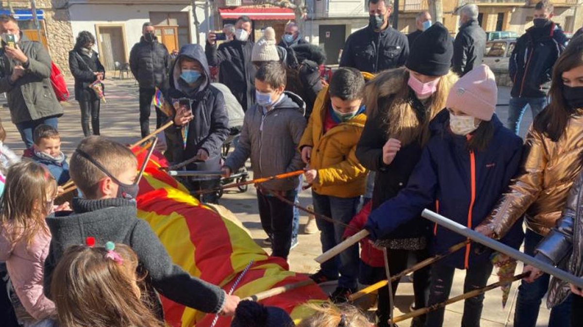 Nens i nenes de Castelldans colpejant el tió durant la celebració d’ahir.