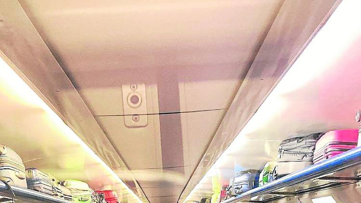 Passatgers asseguts al passadís d’un tren de l’R-13 dimarts.