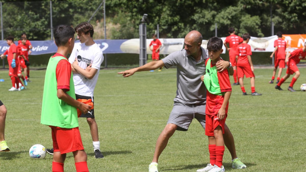 Pep Guardiola da instrucciones a uno de los participantes en el Pep Summer Camp.