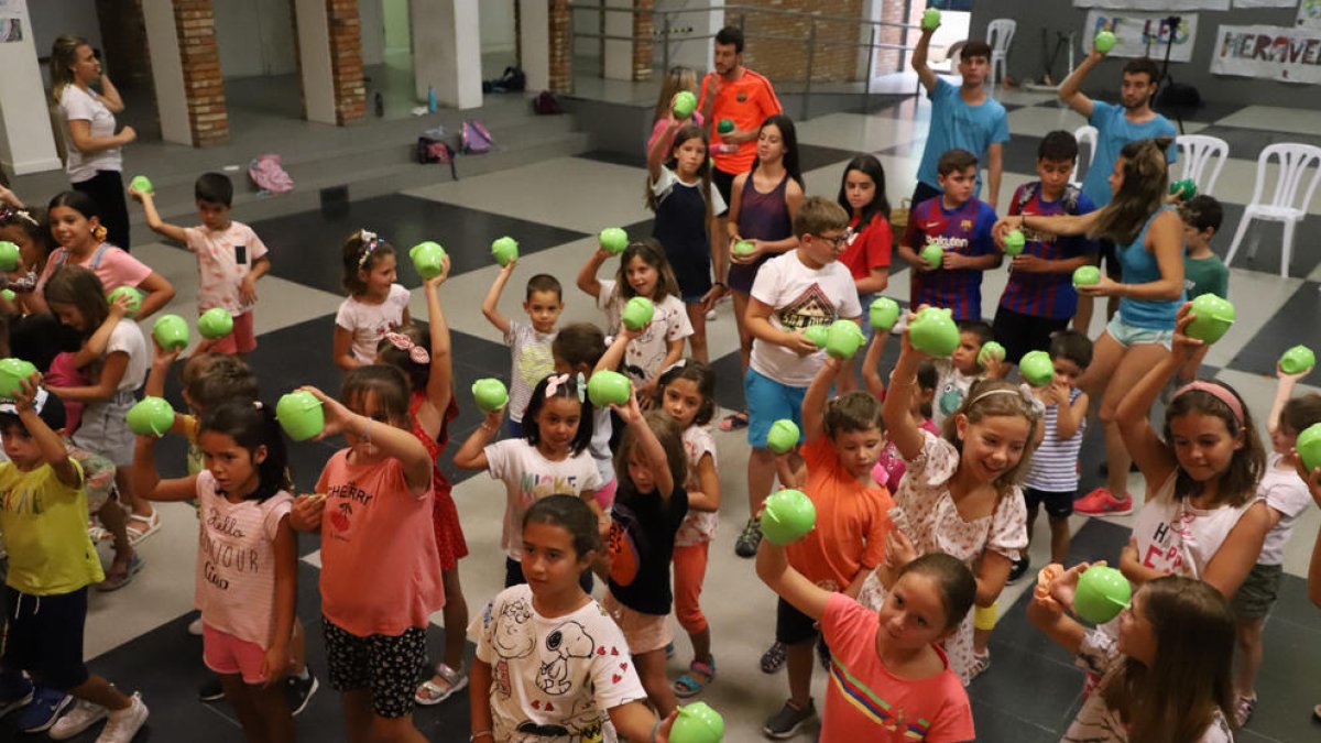 Los niños y niñas enseñaban sus fiambreras en forma de manzana tras finalizar la actuación del grupo La Cremallera en Soses.