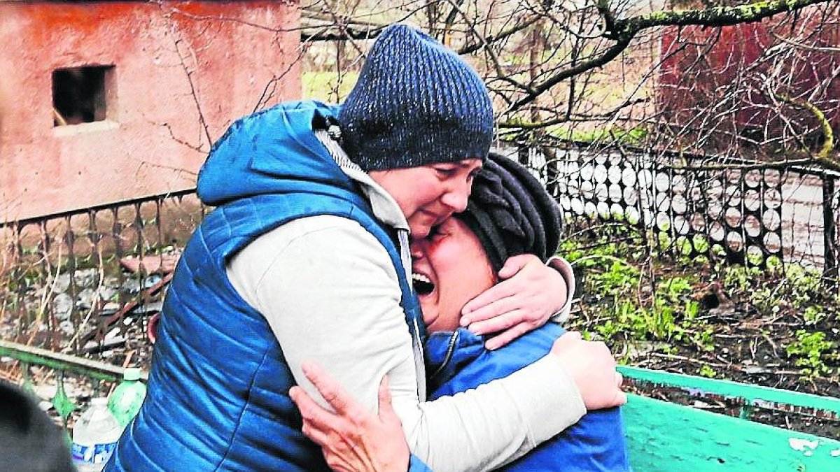 Dos dones ucraïneses s’abracen en un municipi al costat de Kíiv.