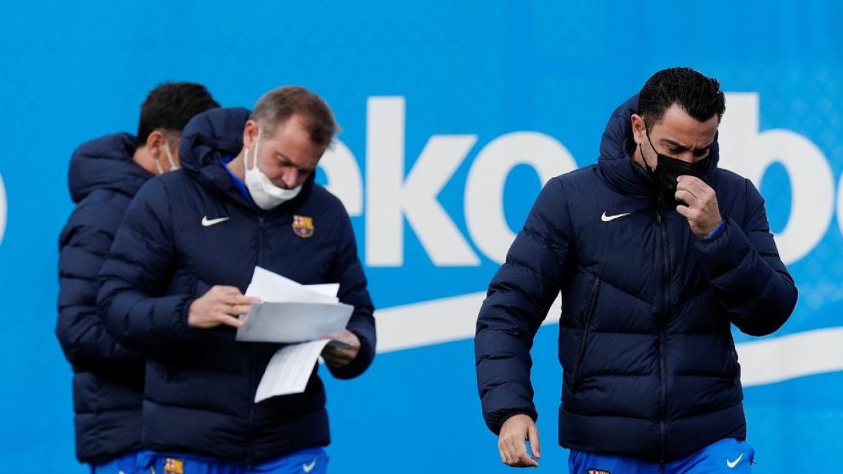 Xavi Hernández, amb un dels seus ajudants, durant l’entrenament d’ahir.