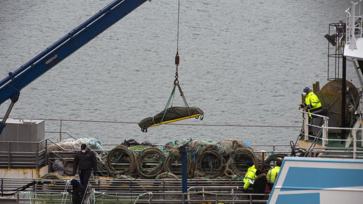 Una grúa descarga a una de las víctimas mortales del naufragio .