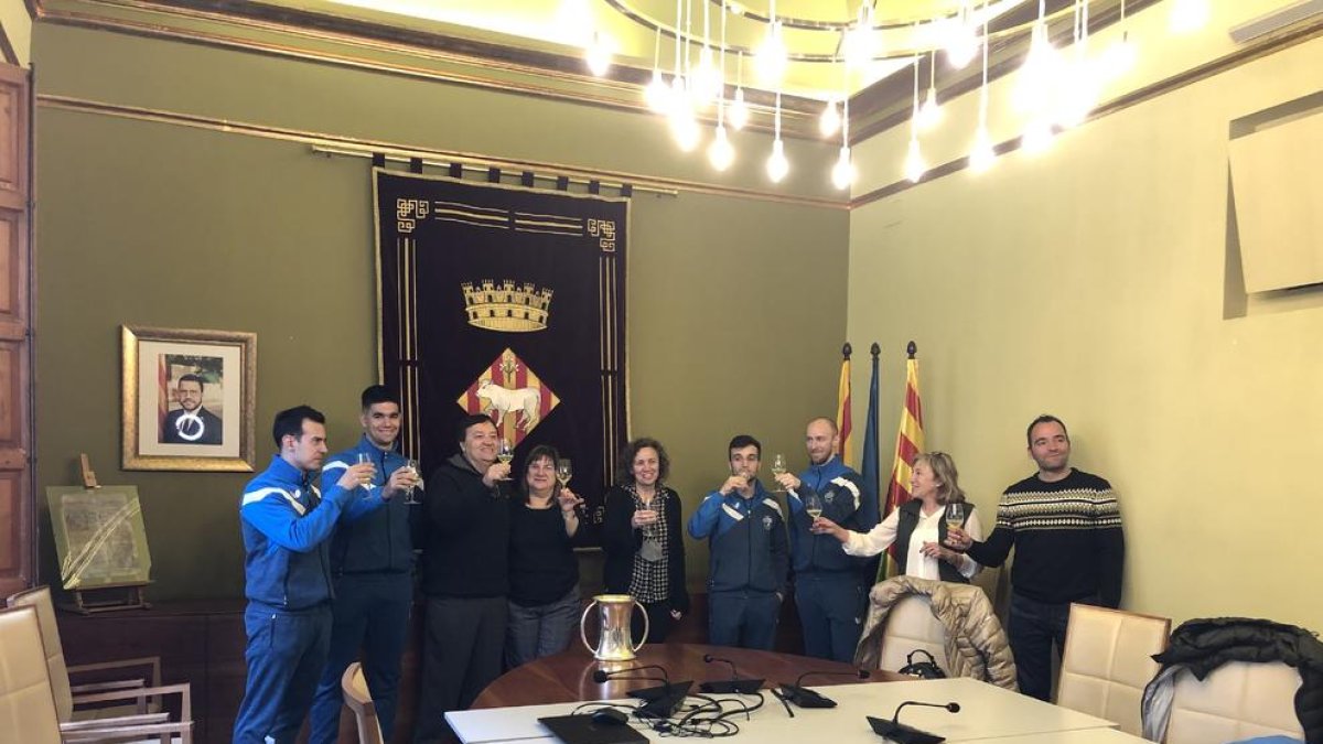 La alcaldesa, jugadores y directivos del club brindan con cava junto al trofeo de la Copa del Rey.