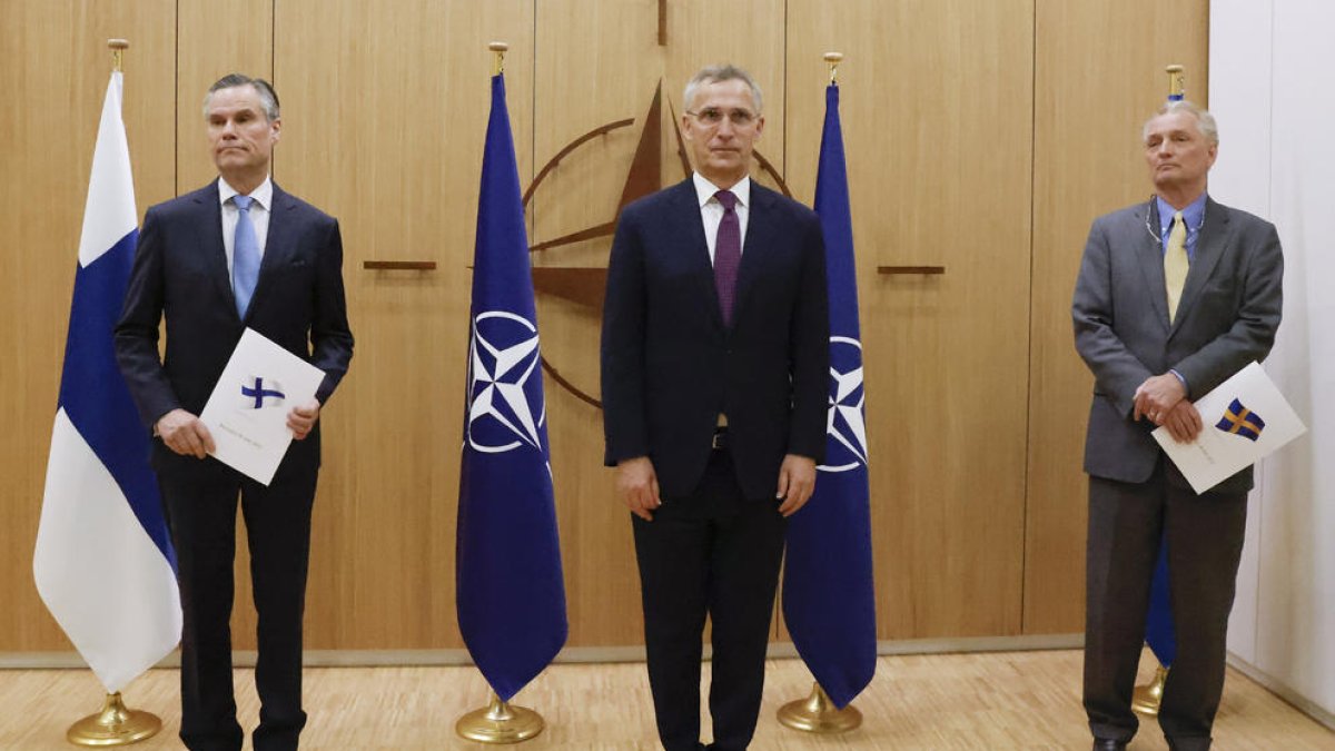 Els ambaixadors finès i suec al costat del secretari general de l’OTAN, Jens Stoltenberg.
