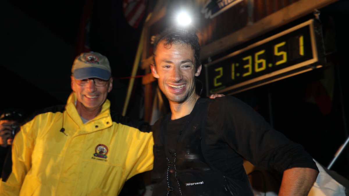 Kilian Jornet, sonriente tras concluir la prueba como vencedor con el tiempo que se ve detrás suyo.