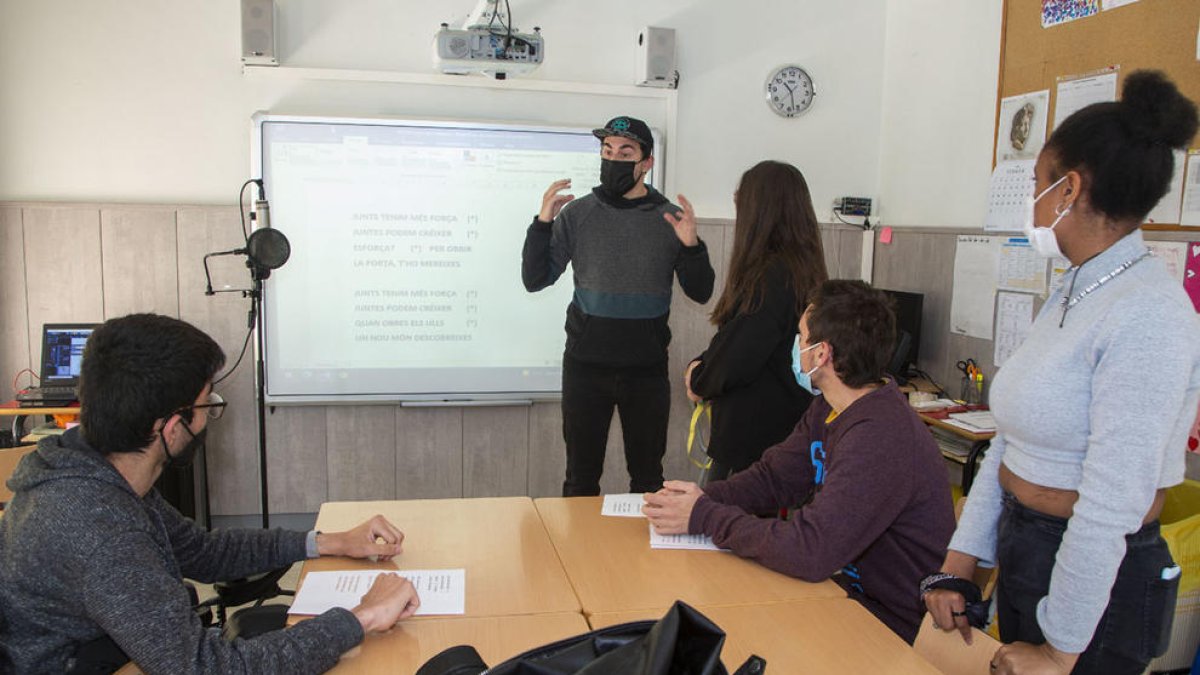 El raper Joel Prieto donant algunes directrius a alumnes del centre abans de gravar la lletra.