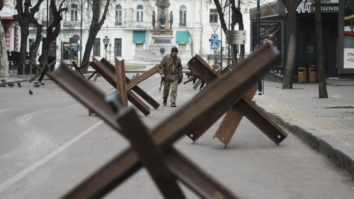 Un militar patrulla entre una barricada antitancs en una ciutat ucraïnesa.