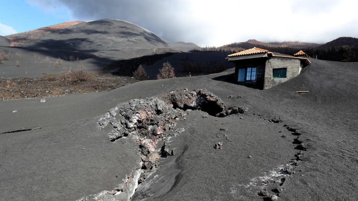 Una de las viviendas que sigue enterrada bajo una masa de cenizas.