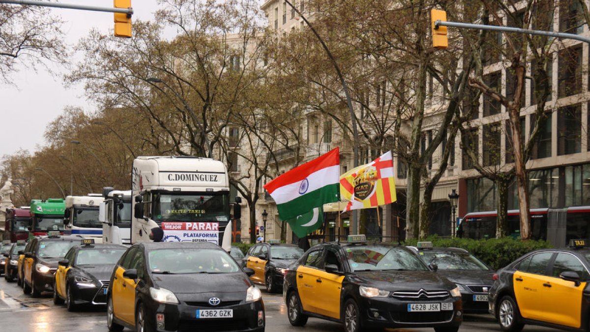 La marcha lenta convocada por los taxistas de Barcelona a su paso por la Gran Vía de la ciudad.