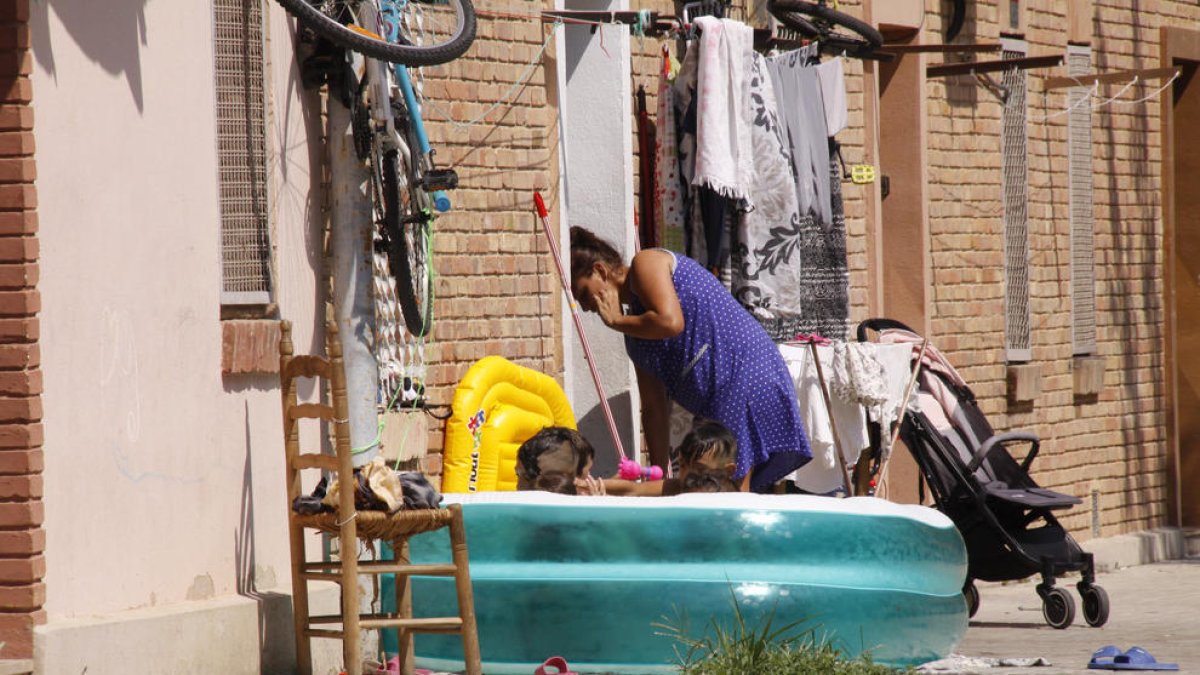 Veïns amb una piscina inflable als carrers de la Mariola.