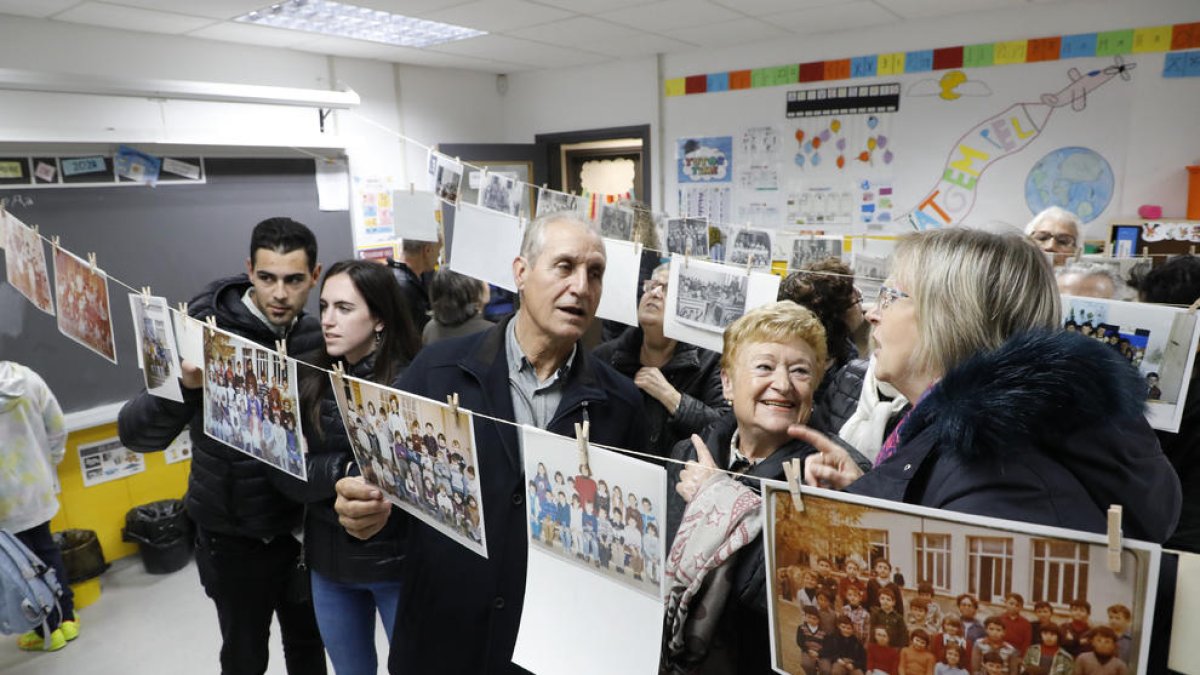 Diverses persones visitant la mostra de fotos antigues que va acollir ahir l’escola Otogesa de Maials.