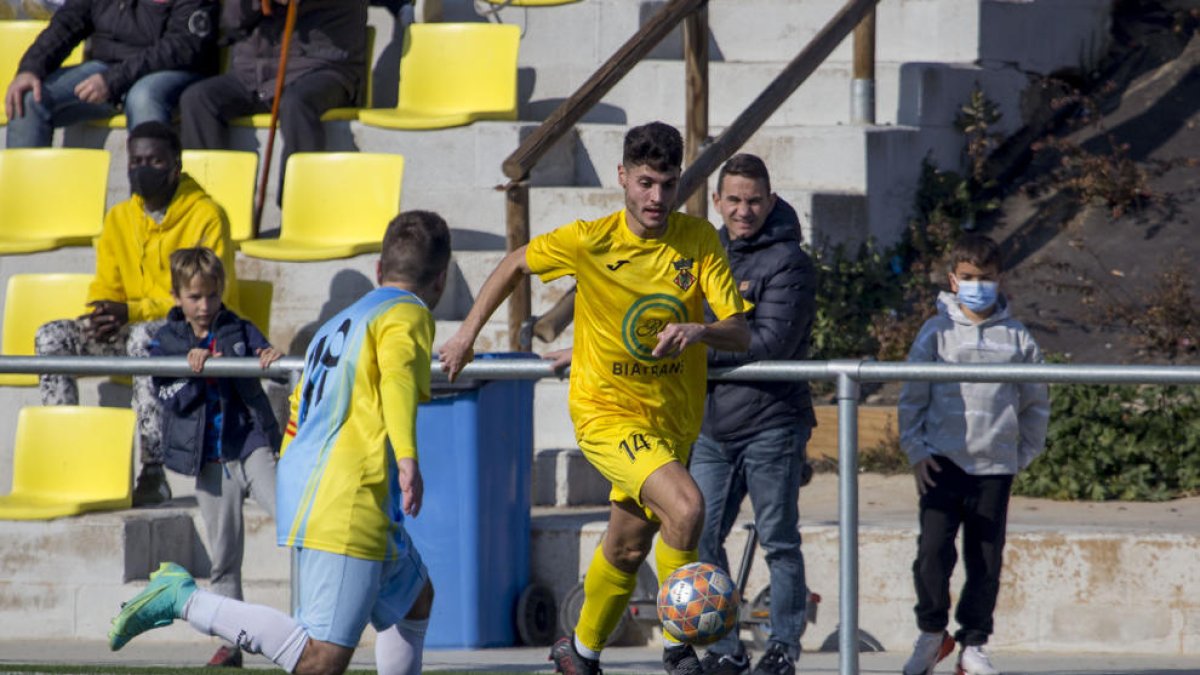 Un jugador del Alcoletge controla el balón por la banda del terreno de juego.