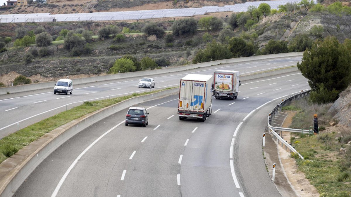 Camiones circulando por el carril central de la A-2 mientras el derecho, muy deteriorado, está vacío.