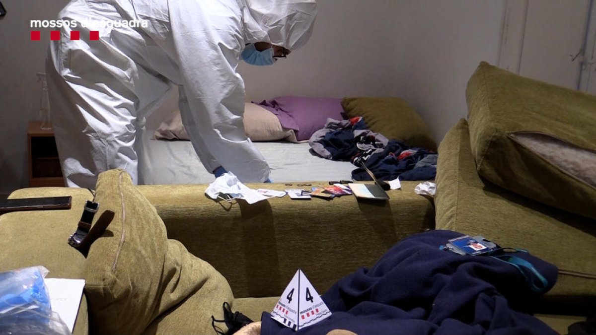 Un policia de la unitat científica recull proves a casa del sospitós durant l’escorcoll.