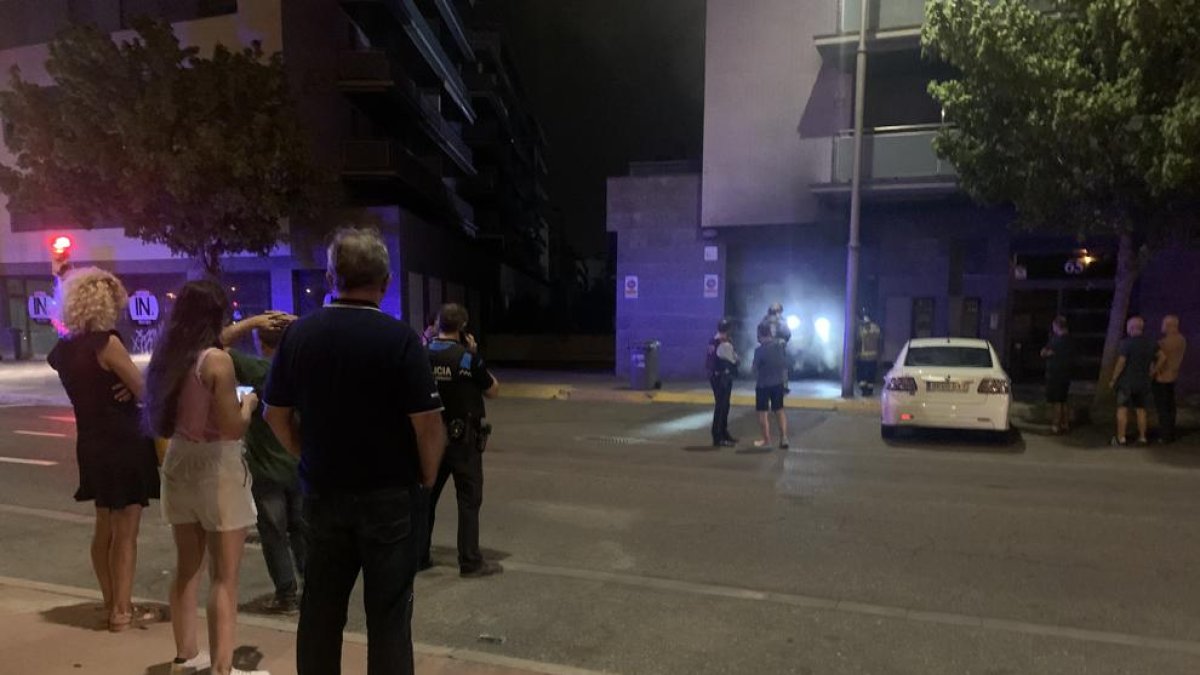 Vecinos observan anoche el trabajo de los Bomberos en el incendio.