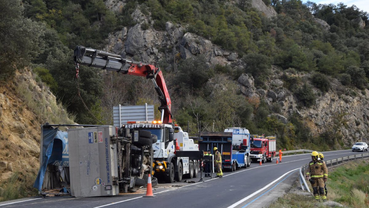 Momento en el que la grúa retira el camión volcado.