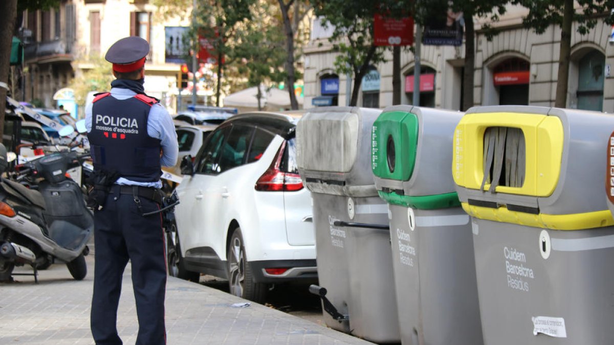 Un mosso, junto al contenedor donde se halló el torso.