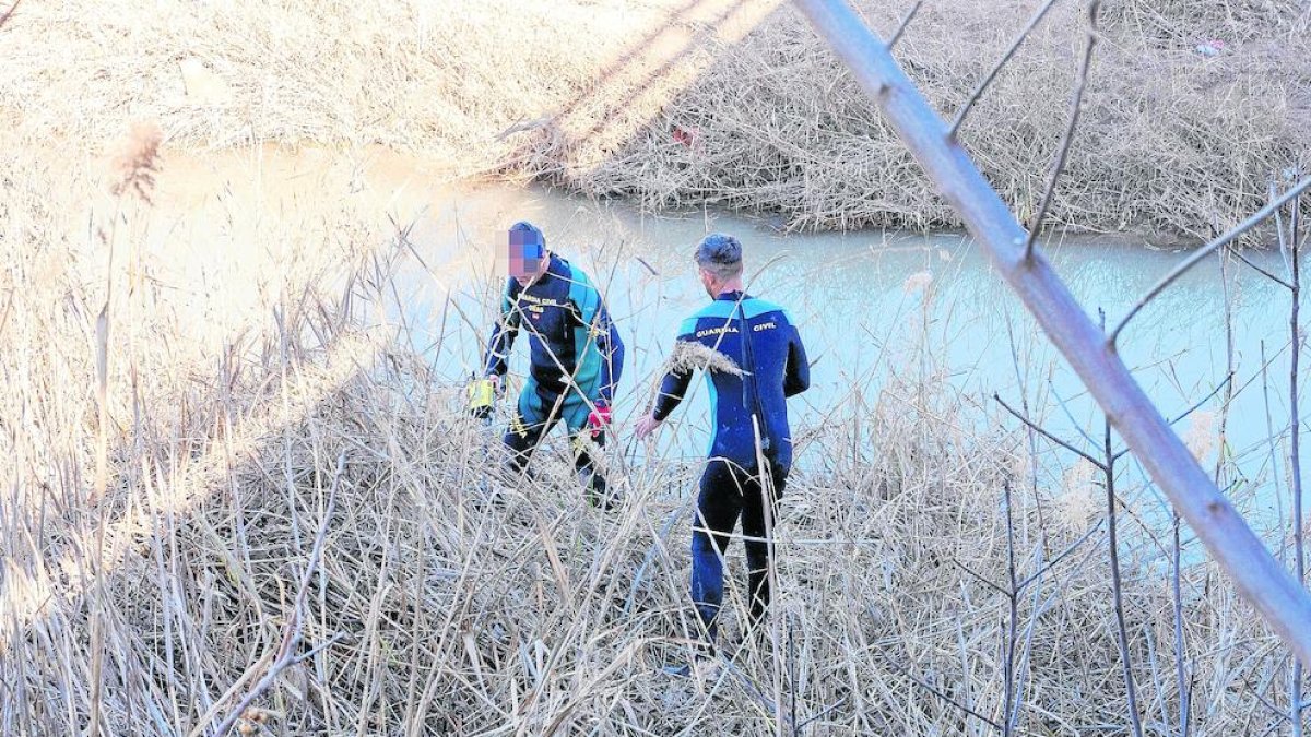 Investigadores buscan el arma homicida en un arroyo.