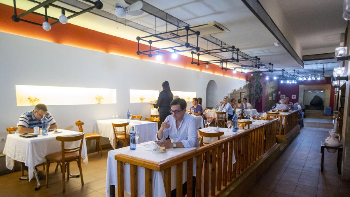 Un home menja just a sota d’un ventilador que ha col·locat el restaurant La Masia, ahir.