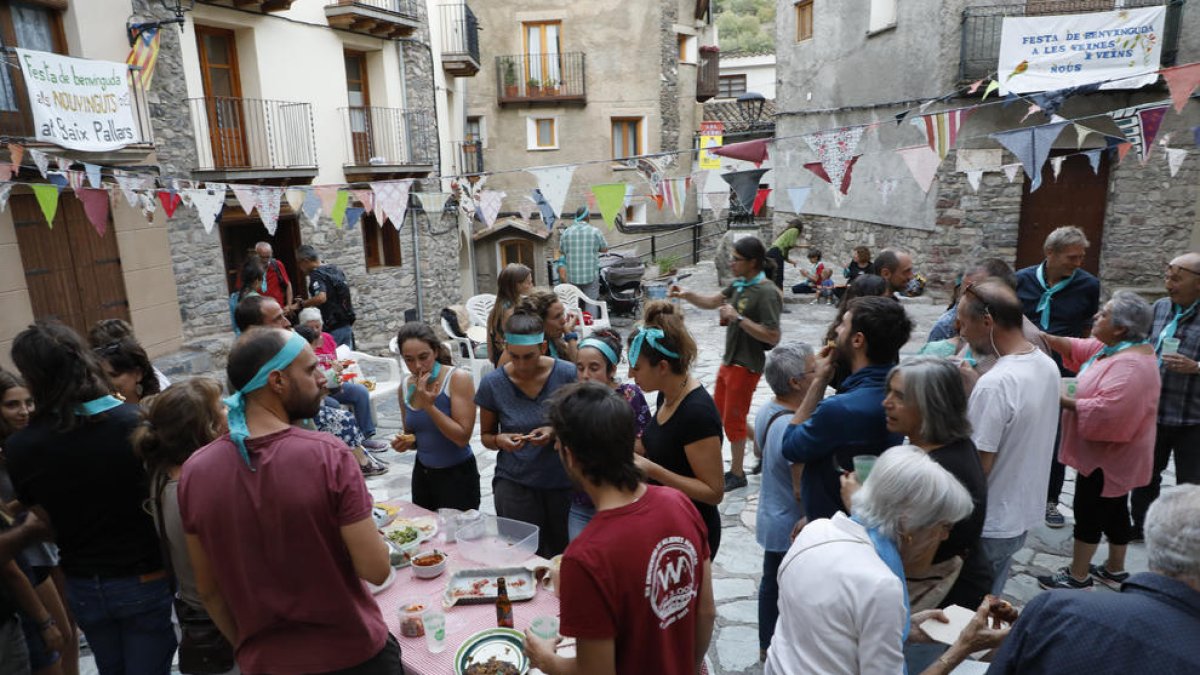 Los nuevos vecinos de Gerri de la Sal, con cintas azules en la cabeza y en el cuello, durante la fiesta de bienvenida que les ofreció el pueblo ayer por la tarde.