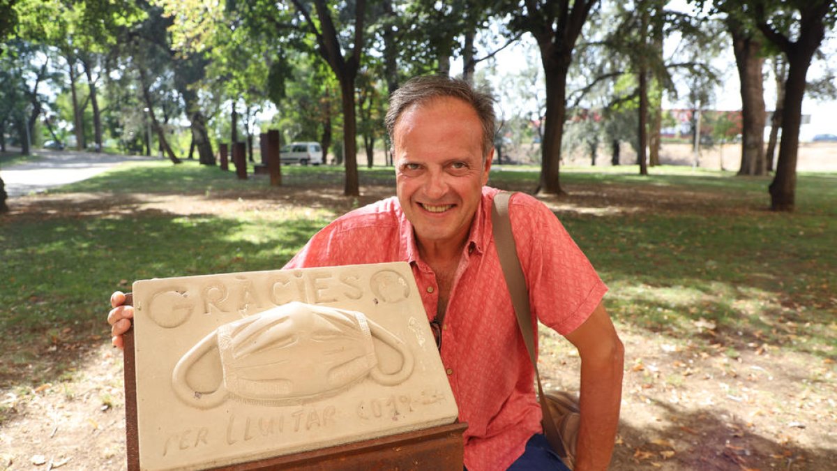 El autor de la obra, Ignasi Arqué, posa con su escultura ayer por la tarde en los jardines del hospital.