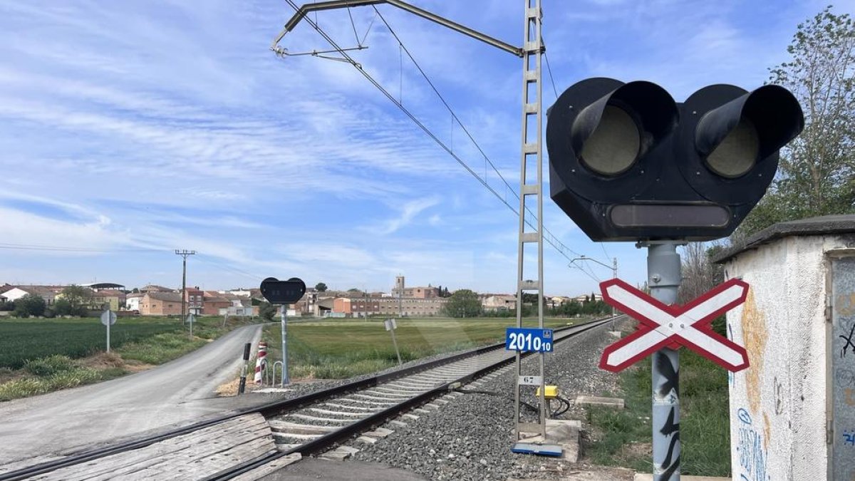 La via del tren que uneix Lleida i Barcelona per Manresa al seu pas per Sidamon, amb el municipi al fons.