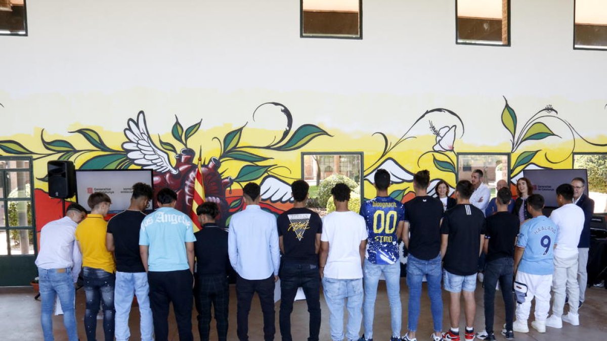 Jóvenes del centro de justicia juvenil El Segre de Lleida pintan uno de los muros del edificio en un proyecto de arte comunitario