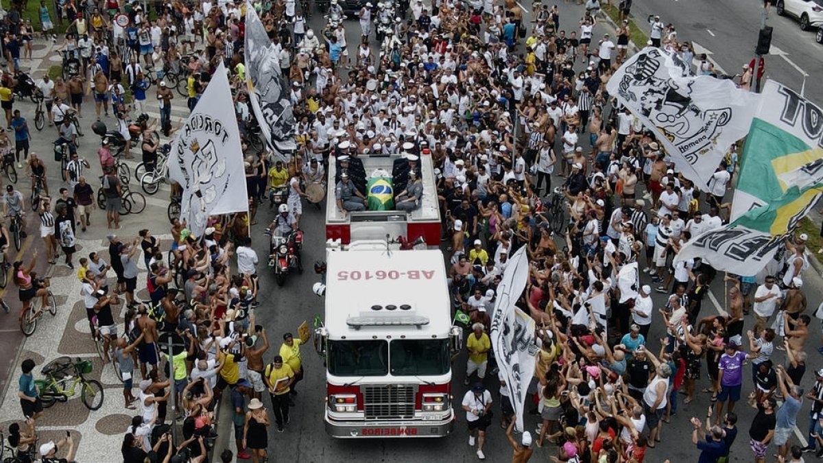Milers d’aficionats van acompanyar pels carrers de Santos el fèretre de Pelé, durant el trasllat al cementiri.