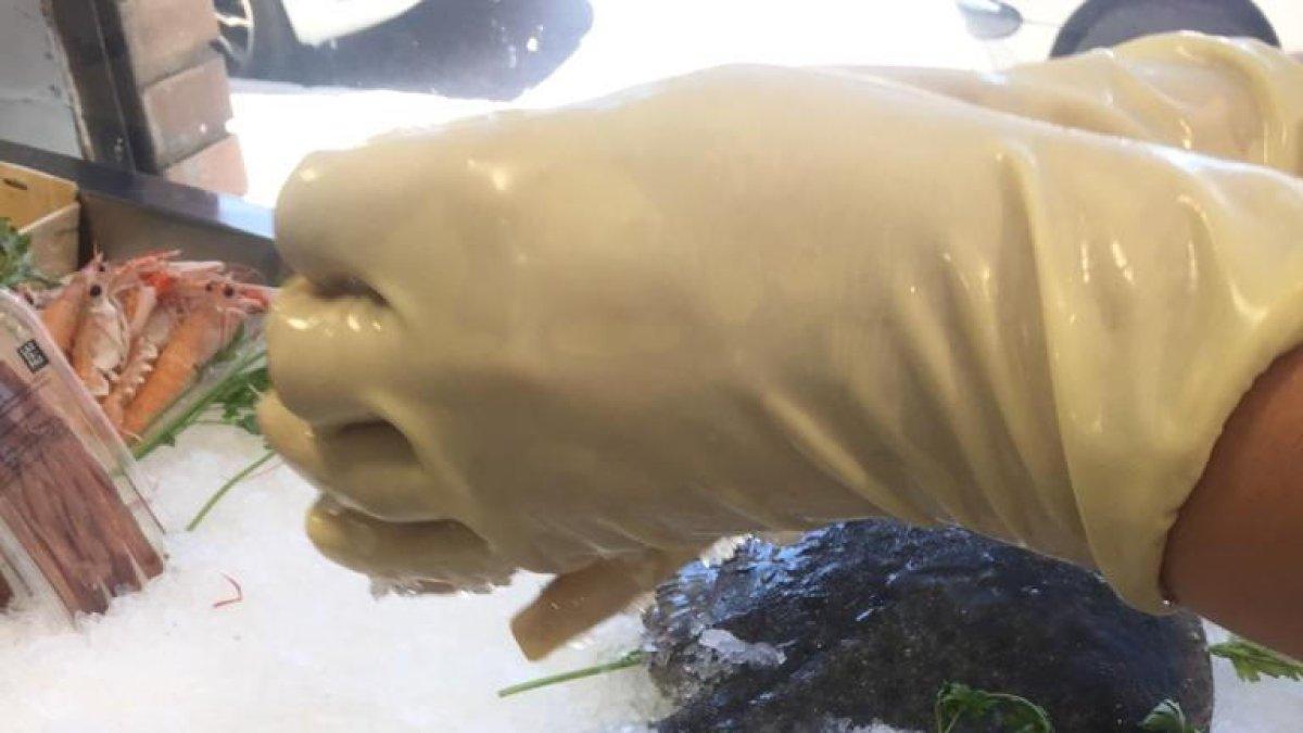 Una pescadera pone hielo al pescado para mantenerlo frío.