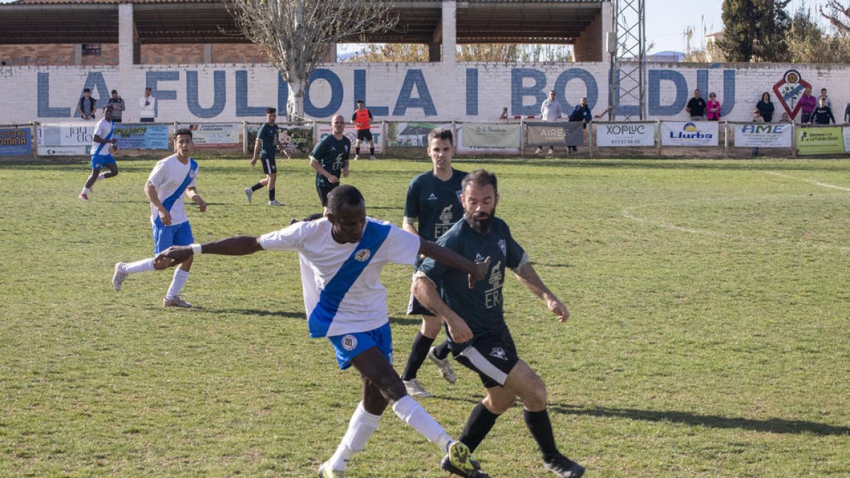 Un jugador local porta la pilota davant la pressió d’un oponent del Vallfogona.