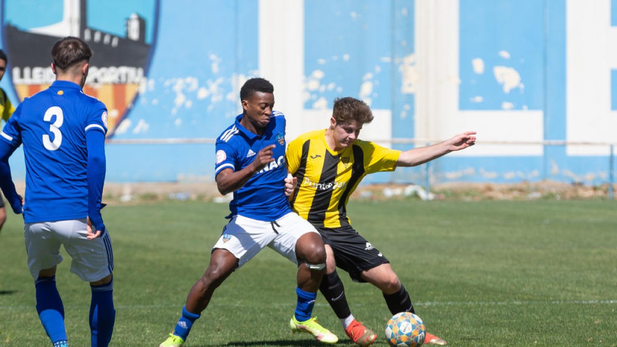 Un jugador del filial del Lleida i un altre del Pardinyes pugnen per la pilota.