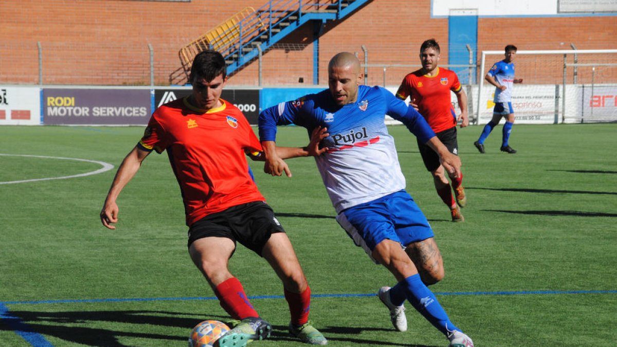 Adrià Fernández, golejador local en el minut 81 al convertir un penal, pressiona un jugador del Martinenc.